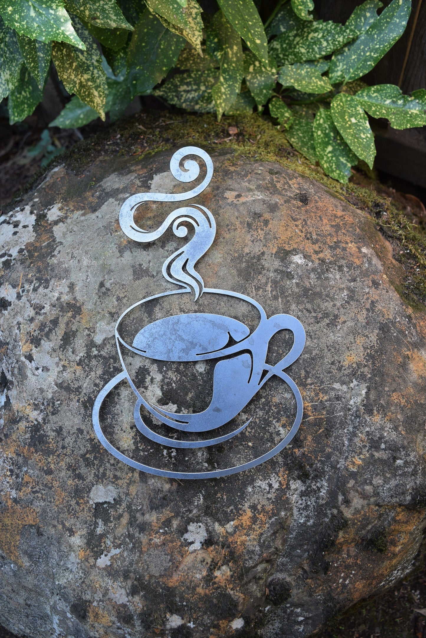 Enhance your space with a steaming coffee cup steel cutout, showcasing a rustic raw steel finish for a unique and inviting ambiance.