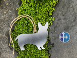 Load image into Gallery viewer, Metal Corgi silhouette ornament resting on rock with green moss.
