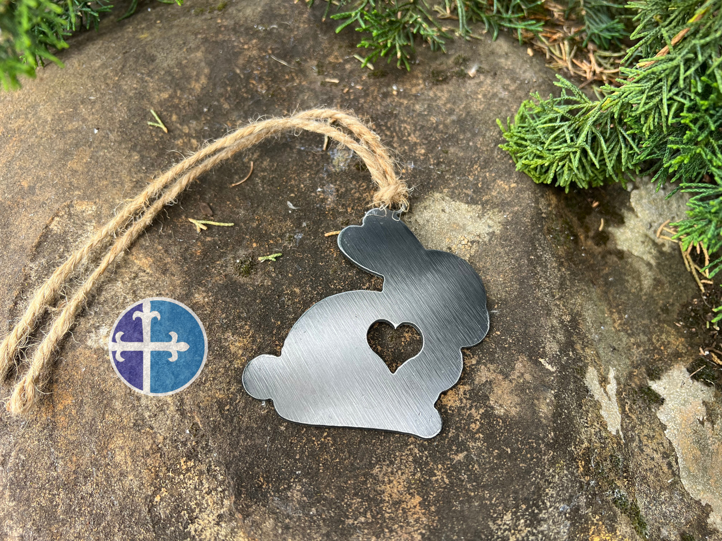 A handcrafted steel bunny ornament with a heart cutout, ideal for adding rustic charm to any decor.