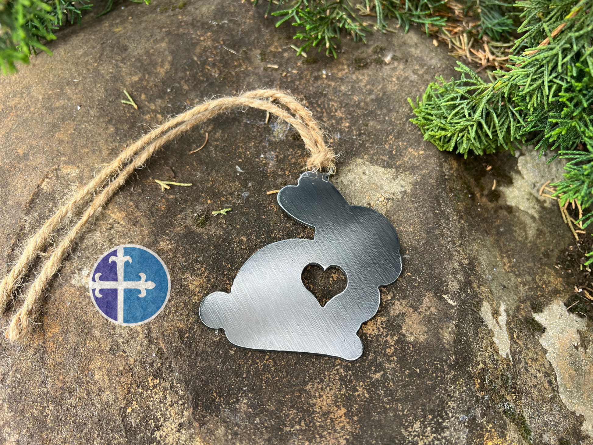 A handcrafted steel bunny ornament with a heart cutout, ideal for adding rustic charm to any decor.