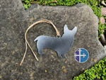 Load image into Gallery viewer, Corgi dog-shaped metal ornament with hanging twine displayed outdoors.
