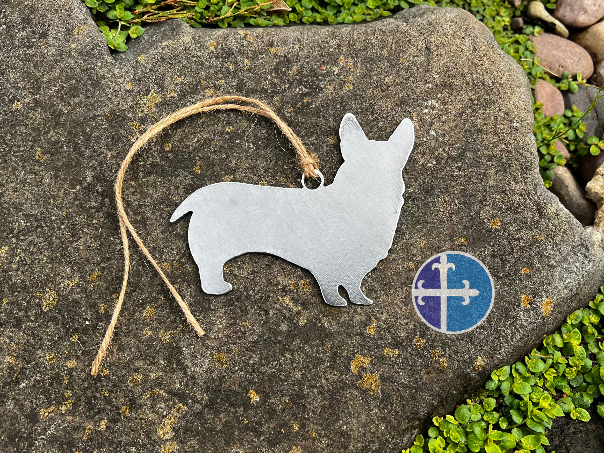 Single Corgi silhouette ornament made from steel, rustic outdoor background.