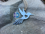 Load image into Gallery viewer, Rustic steel hummingbird decoration, laying on gray stone, showing heart detail.
