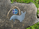 Load image into Gallery viewer, Brushed steel Corgi dog ornament with twine hanger on stone background.
