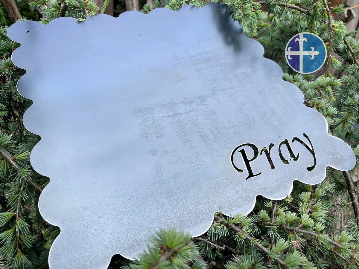 Square steel magnet board with scalloped edges, two mounting holes, and Pray cut into the lower corner.