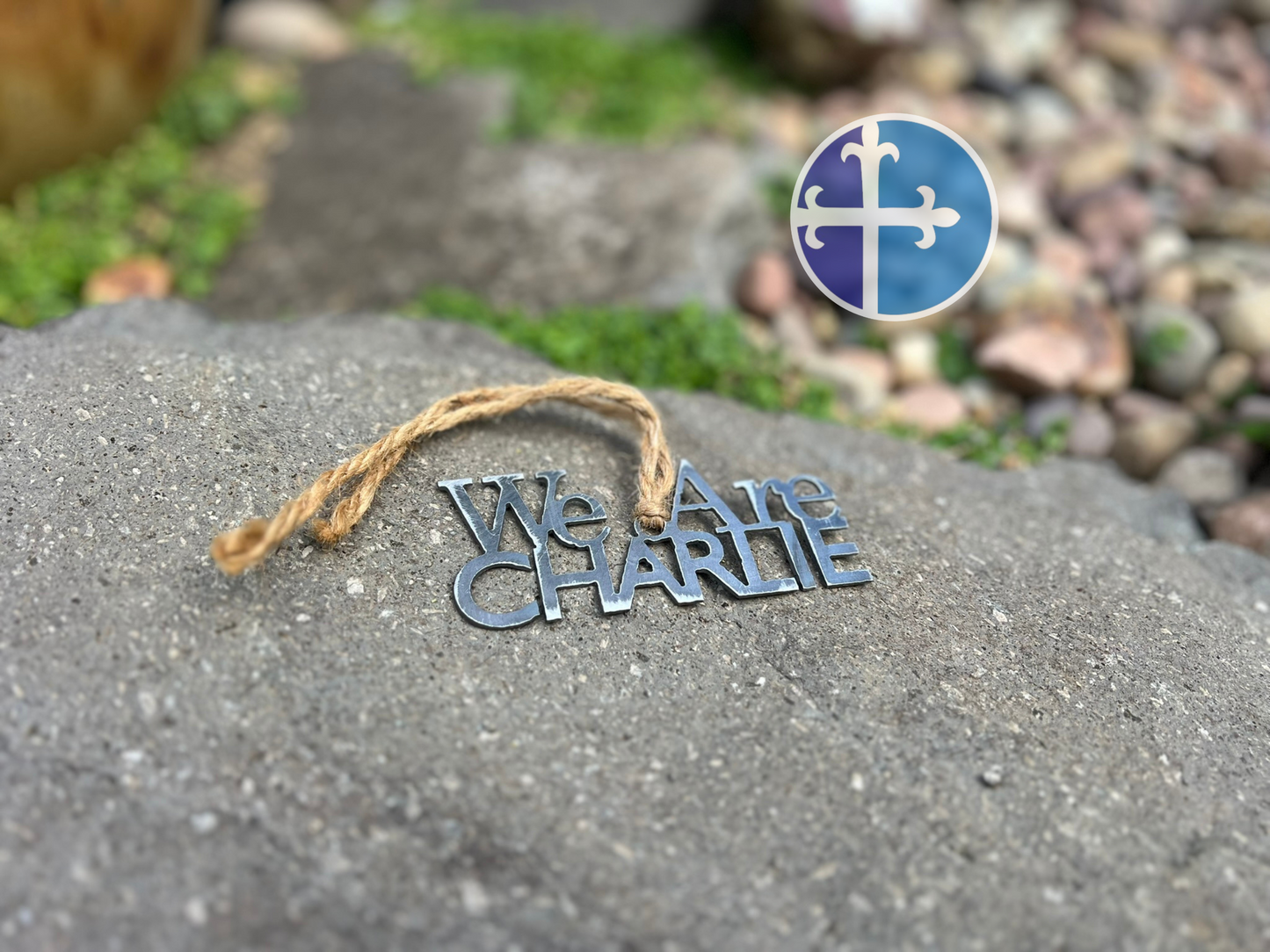 Patriotic metal ornament with rustic finish, laid near decorative stones.