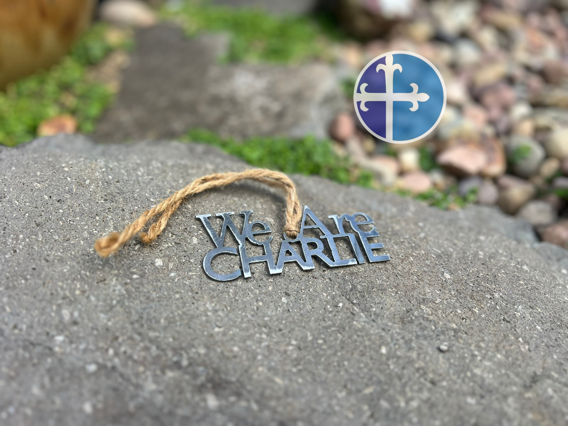 Patriotic metal ornament with rustic finish, laid near decorative stones.