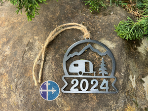 Top view of the metal 2024 camper ornament with mountain, RV, and tree design, showing its rustic charm and durable steel finish.