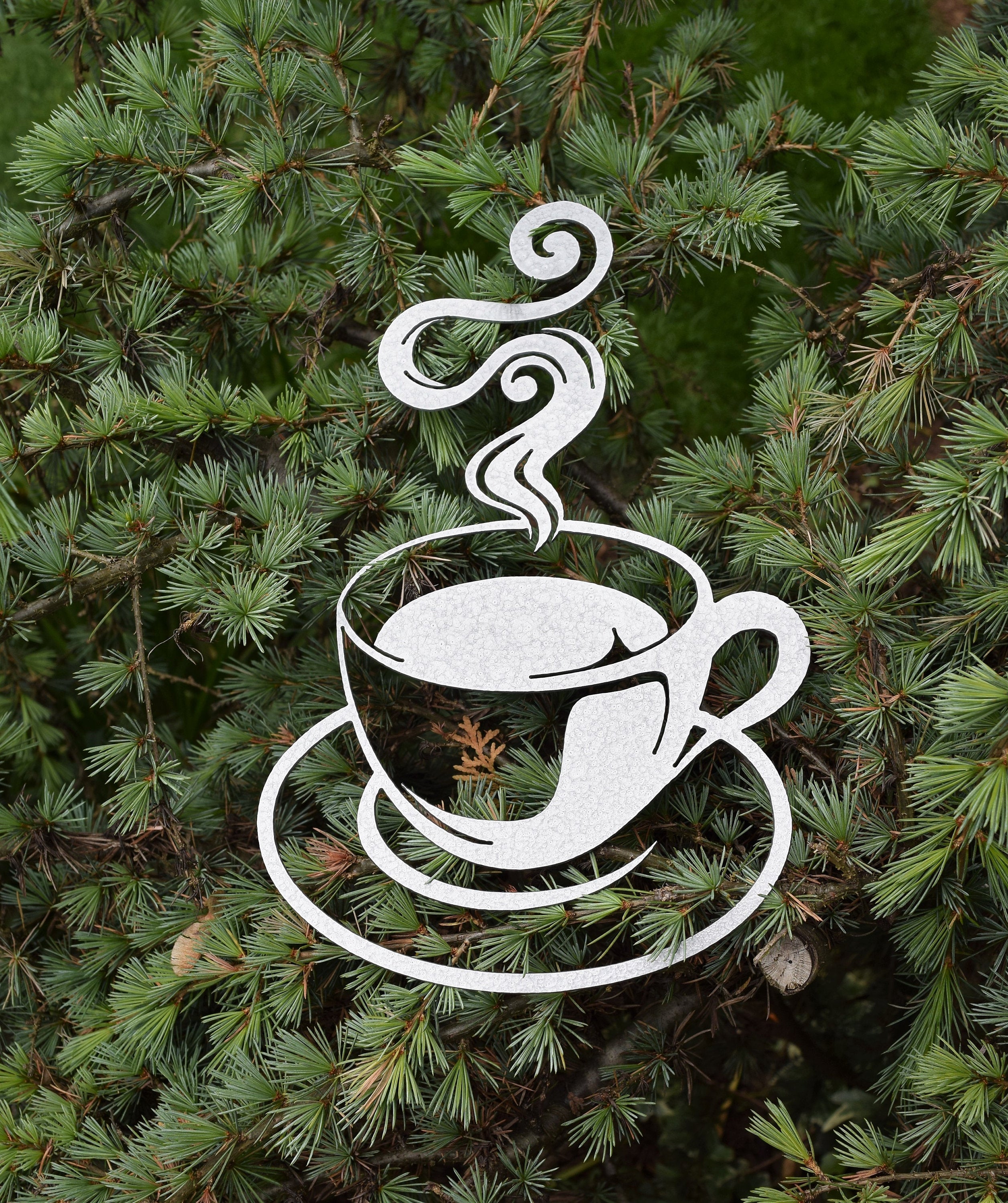 Discover artisanal charm with our hammered silver-painted steel cutout of a steaming coffee cup, perfect for elevating your home decor. This unique coffee-themed art piece adds a touch of elegance and warmth to any space. Ideal for coffee enthusiasts and interior design aficionados alike.