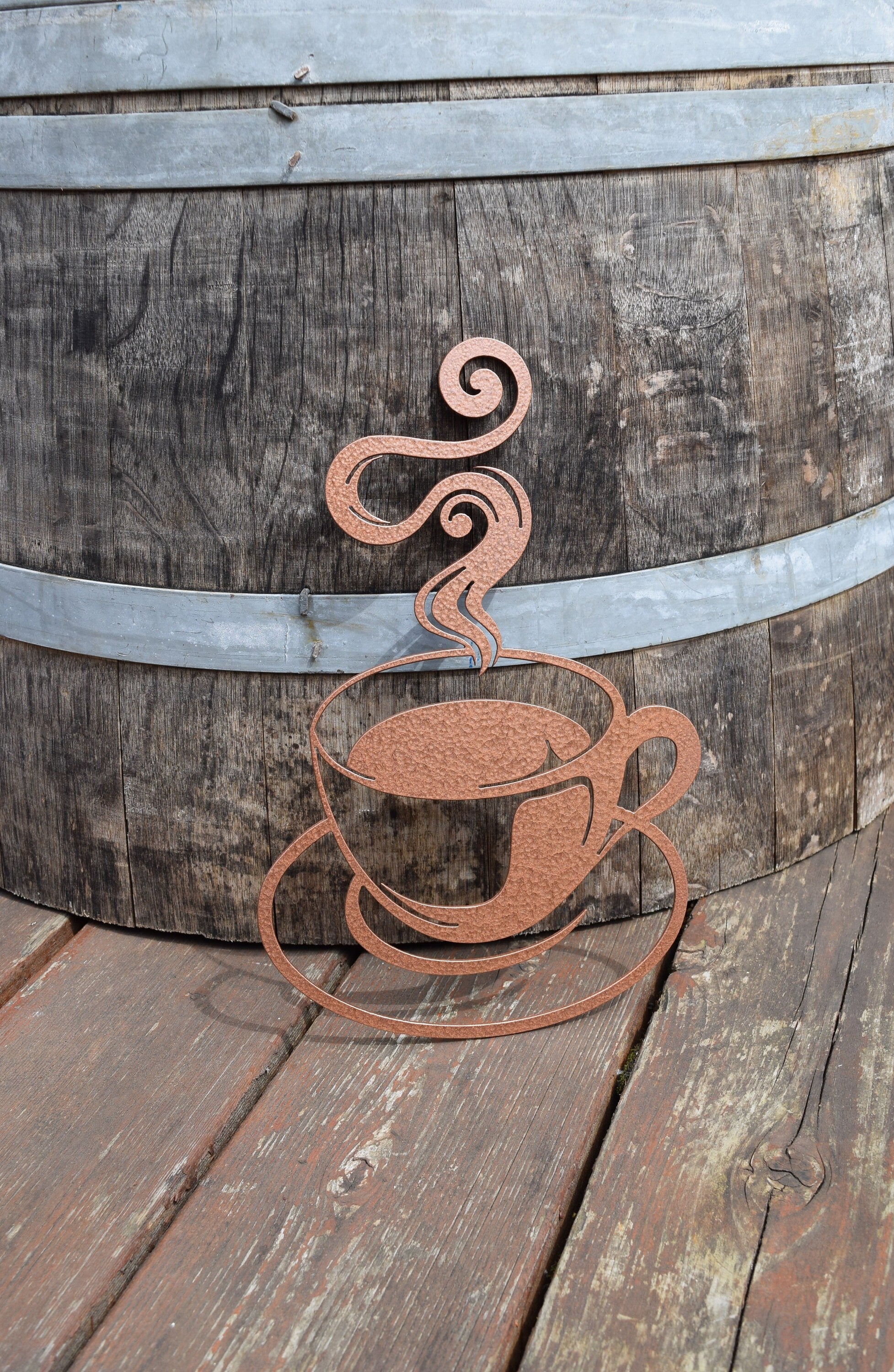 Enhance your decor with a hammered copper-painted steel coffee cup cutout, radiating warmth and sophistication, perfect for adding a cozy touch to any space